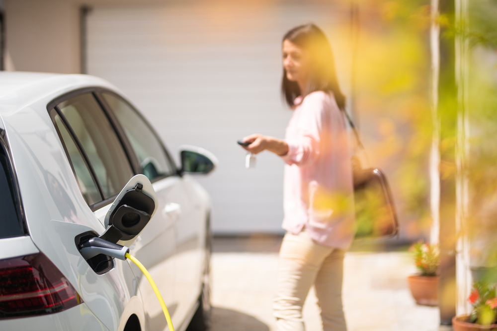 kvinna som laddar sin elbil, kvinna som låser bilen